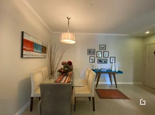 Sala de estar com mesa de jantar e decoração de parede.