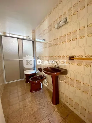 Foto de um banheiro com revestimento de azulejos e pias de madeira.