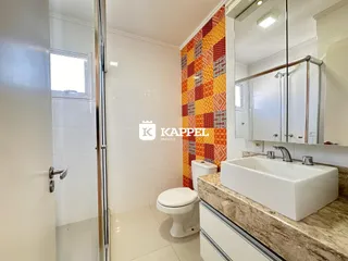 Banheiro com revestimento de azulejos brancos e bancada de granito.