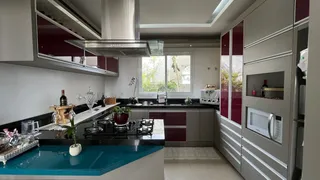 Cozinha moderna com armários em tons de cinza e vinho e ilha azul.