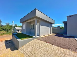 Vista externa de uma casa moderna em Lajeado, Brasil, com jardim e área de acesso.