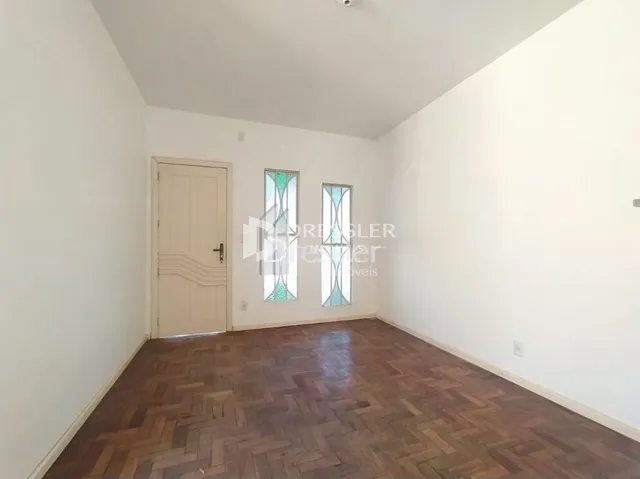 Interior de um ambiente com piso de madeira e porta branca.