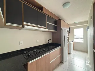 Uma cozinha moderna com armários e bancada escura.