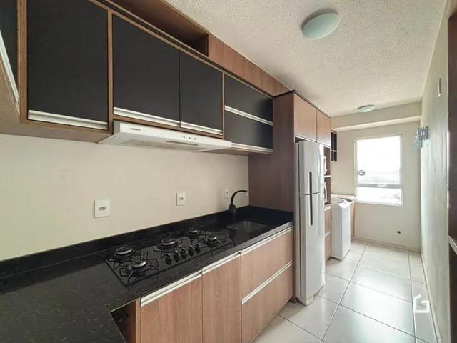 Uma cozinha moderna com armários e bancada escura.