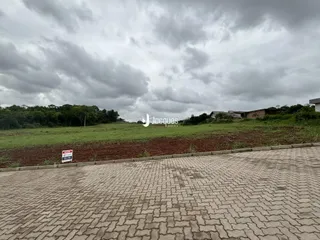 Vista da propriedade em Lajeado, Brasil, com campo gramado e vegetação ao fundo.