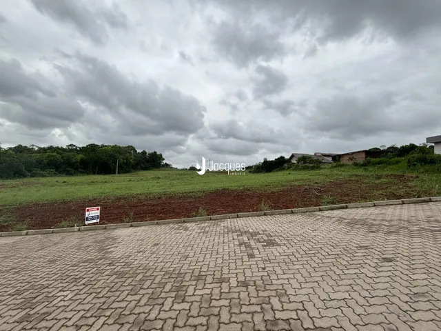 Vista da propriedade em Lajeado, Brasil, com campo gramado e vegetação ao fundo.