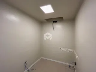 Hall da frente com paredes brancas e teto claro.