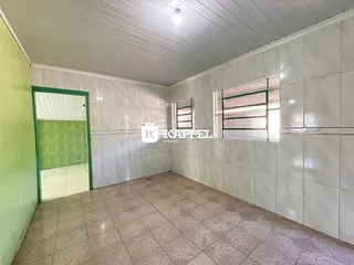 Hall de corredor com paredes e piso de cerâmica claros.