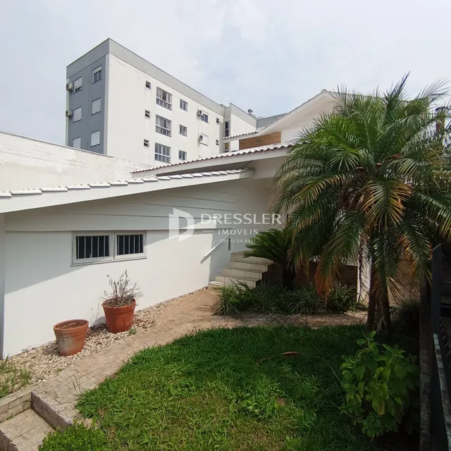 Fachada de uma residência em Lajeado, Brasil com jardim e palmeira.