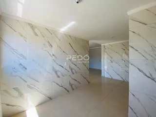 Hall de entrada com revestimento em mármore branco nas paredes.