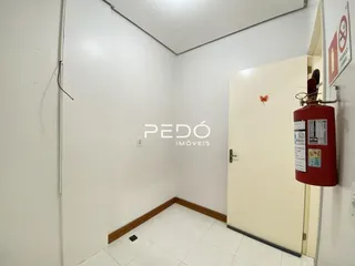 Hall de entrada com paredes brancas e piso claro.