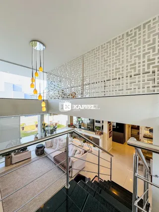 Escadaria moderna com guarda-corpo de vidro em um interior de apartamento.