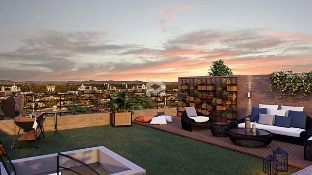 Vista de um terraço com decoração de jardim e móveis ao pôr do sol.