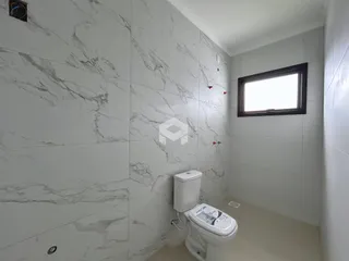 Foto de um banheiro com revestimento de mármore branco.