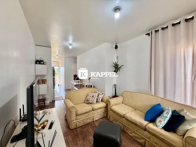 Foto de uma sala de estar com dois sofás e uma televisão.
