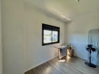 Ambiente interno com piso de madeira e janela.