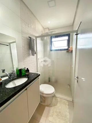 Foto de um banheiro interno com revestimento de cerâmica e box de vidro.