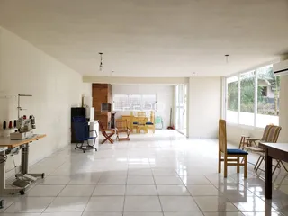 Ambiente interno amplo com piso de cerâmica claro e grande janela.