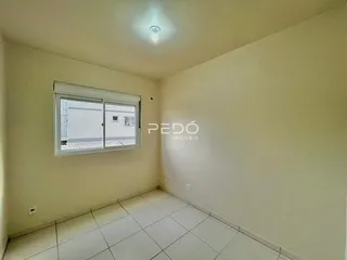 Ambiente interno de uma sala com piso cerâmico e parede clara.