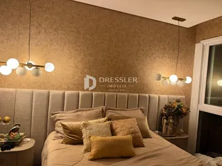 Quarto com cabeceira estofada e decoração neutra em um imóvel no Brasil.
