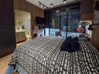 Quarto com cama grande e decoração moderna em madeira.