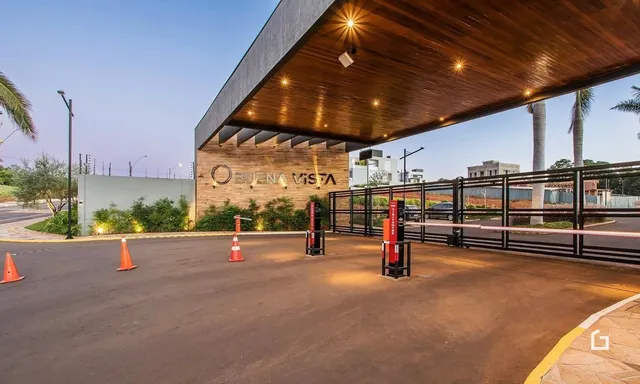 Vista externa da propriedade com cerca e entrada.