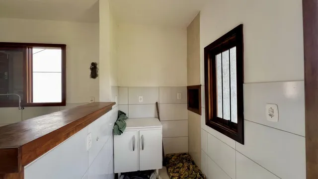 Foto de um corredor interno com armários brancos e detalhes em madeira.
