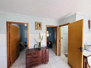 Hall de entrada com portas de madeira e piso cerâmico.