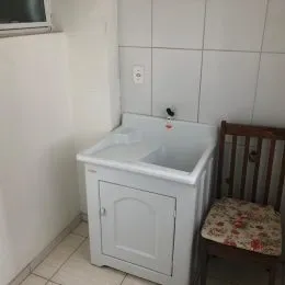 Pia de banheiro branca com gabinete.
