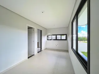 Interior de um corredor com grande janela em uma residência.