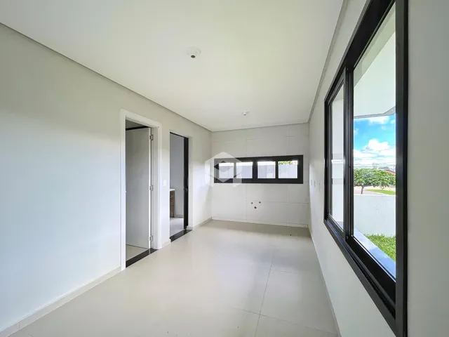 Interior de um corredor com grande janela em uma residência.