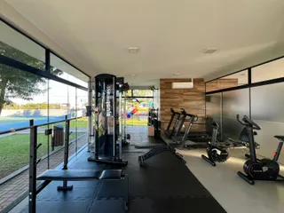 Vista interna de uma área de ginástica com grandes janelas.