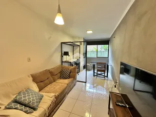 Sala de estar com sofá e piso de cerâmica em um imóvel no Brasil.