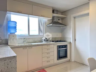 Cozinha moderna com armários brancos e bancadas claras.