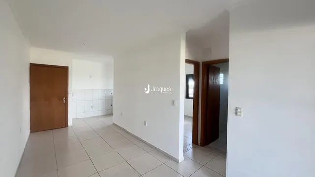 Hall de entrada com piso de cerâmica e paredes brancas.