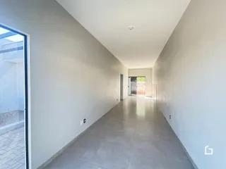 Corredor interno com piso de cerâmica e paredes brancas.
