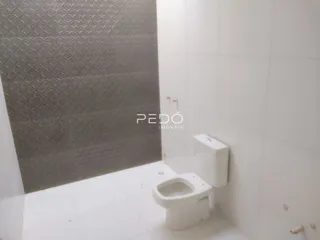 Foto de um banheiro com piso branco e paredes cinzas.