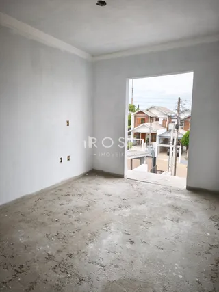 Ambiente interno de um cômodo com piso de concreto cru.