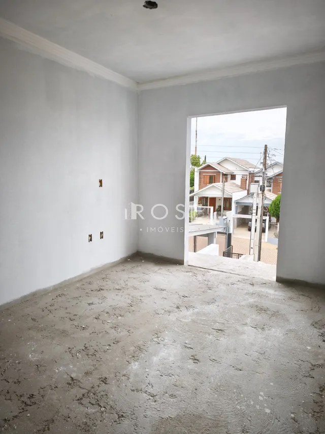 Ambiente interno de um cômodo com piso de concreto cru.