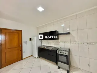 Cozinha com armários pretos e revestimento de azulejos brancos.
