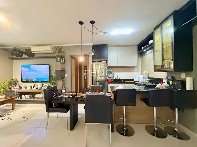 Interior de uma sala de estar com cozinha aberta em um imóvel no Brasil.