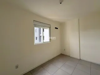 Interior de um cômodo com paredes brancas e piso de cerâmica.