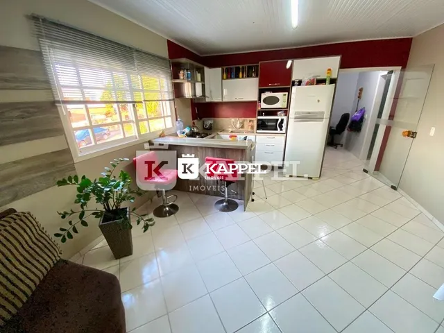 Foto interna de uma cozinha com armários e piso de cerâmica clara.