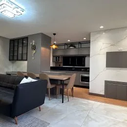 Foto de uma sala de estar com piso claro e iluminação moderna.