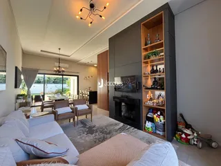 Sala de estar moderna com lareira e grandes janelas de vidro.