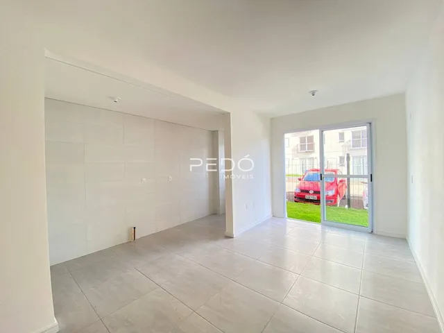 Ambiente interno de uma sala ampla com piso de cerâmica clara.