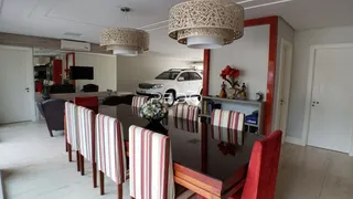 Vista interna de uma sala de jantar com mesa de madeira e cadeiras listradas.