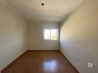 Ambiente interno com piso de madeira clara e janela.
