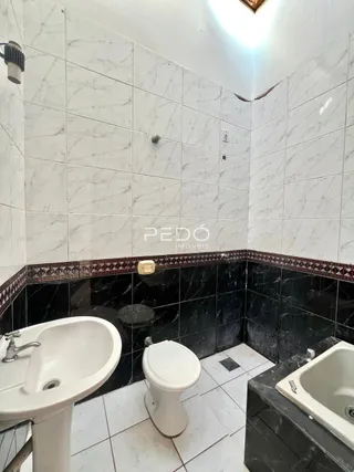 Foto de um banheiro com revestimento de azulejos brancos e pretos.