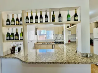 Uma cozinha com prateleiras de madeira exibindo garrafas de vinho.